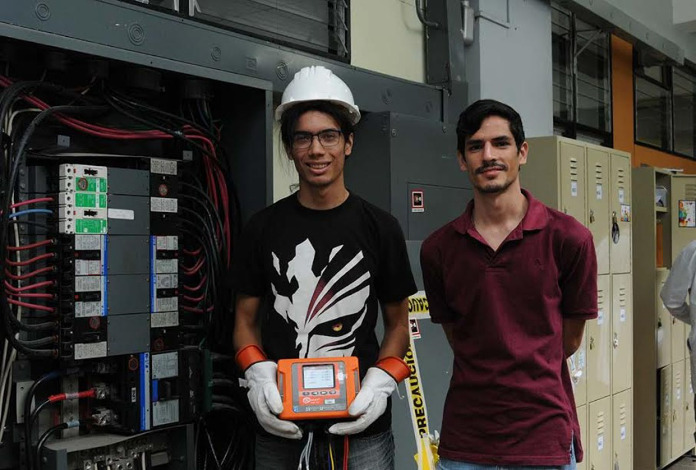 El estudiante Adrián Salcedo y el profesor Oldemar Rodríguez con el equipo de medición de consumo eléctrico (foto Karla Richmond).